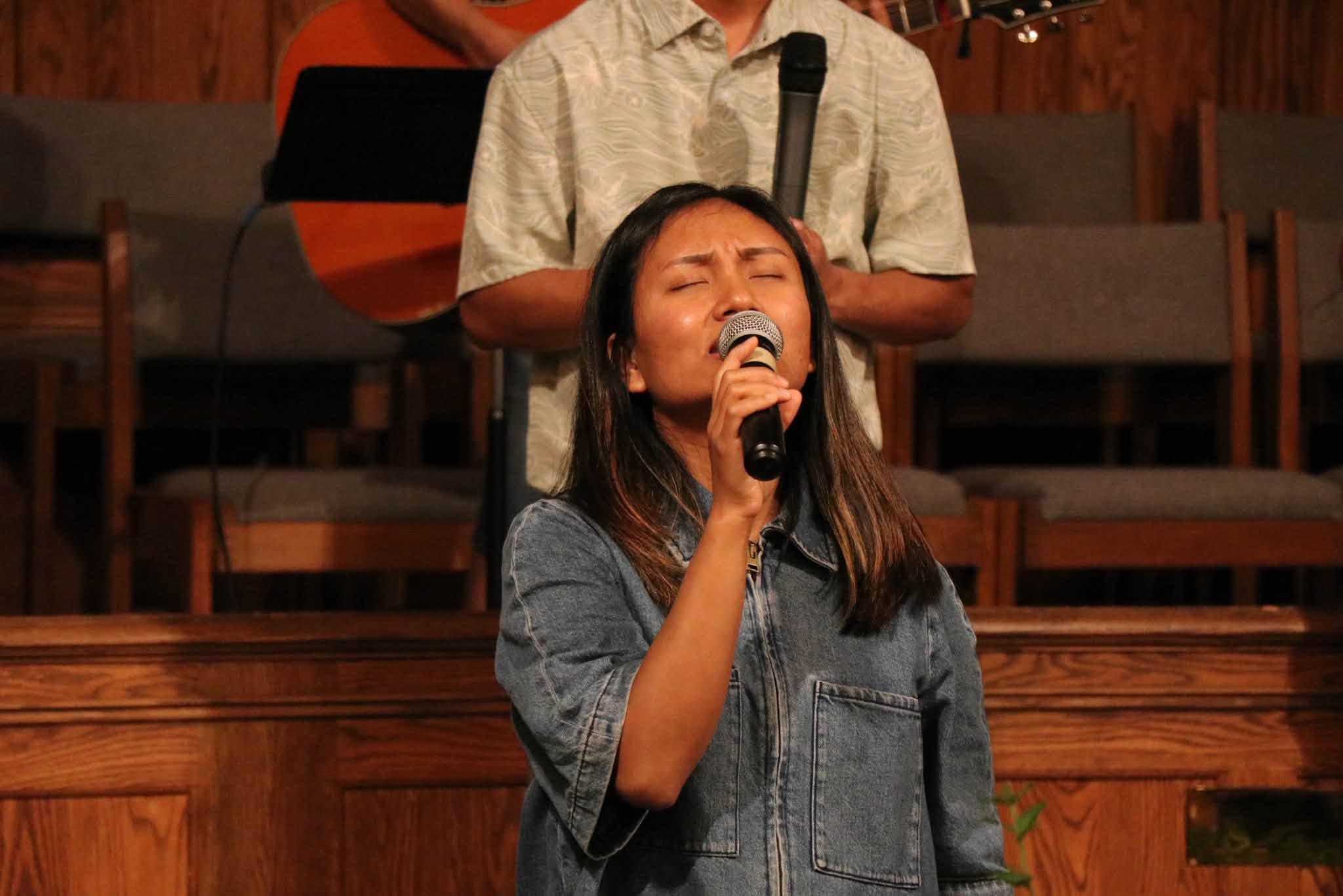 A worship leader singing at Zomi Christian Church
